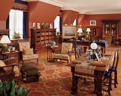 a living room filled with furniture and bookshelves next to a window covered in curtains