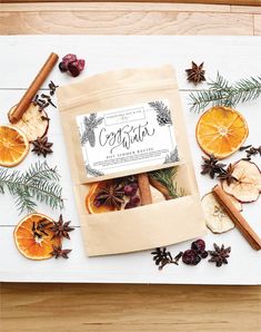 an assortment of dried fruit and spices on a white surface with cinnamons, orange slices, pine cones, fir branches, and cinnamon sticks