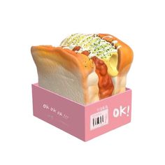 a hot dog with mustard and ketchup in a pink cardboard box on a white background