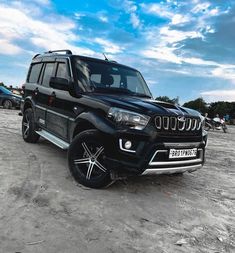 a black suv is parked in the dirt