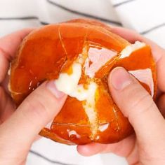 someone is peeling an orange into pieces with white icing on them and holding it in their hands