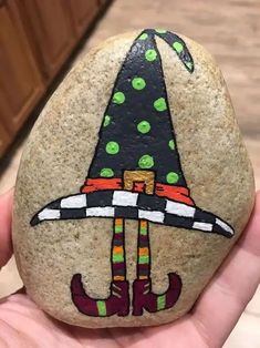 a hand painted rock with a witch hat on it