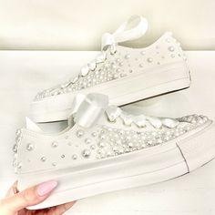 Stunning all white low Converse Platform, faux leather with gold hints, beautifully embellished with : - Fully embellished toe caps and back strips with Pearls and Swarovski crystals - Pearls and Swarovski crystals embellished on the outsides of the shoes in a spray gradual fade effect starting from the front and fading to the back - Finished with Beautiful full satin laces Available with all 4 sides of the shoe embellished with pearls or just the outsides of the shoes embellished (2 sides) (This photo shows 2 sides) White Converse Wedding Shoes, Embellished Low-top Wedding Sneakers, Pearl Embellished Lace-up Wedding Sneakers, Embellished Lace-up Sneakers For Weddings, White Embellished Sneakers For Party, White Embellished Party Sneakers, White Embellished Low-top Wedding Shoes, Wedding White Embellished Sneakers, Platform Converse Wedding