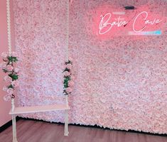 a room with pink walls and flowers on the wall, including a white swing chair