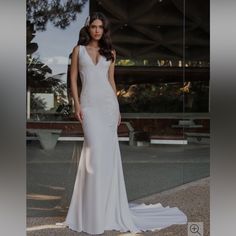 a woman in a white wedding dress standing outside