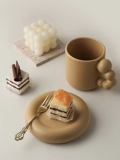 there is a piece of cake on a plate next to a cup and fork, with other desserts in the background