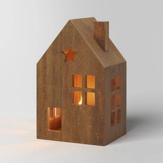 a small wooden house with a lit candle in the window and stars on the roof