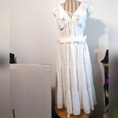 For Size Reference Was Modeled On A Small Mannequin. Brand New With Tags Attached, Also An Extra Button. White Cotton With A Pattern, See Pics For Close-Up. V Neck With A Tie At The Front, Lined Bodice Cups Sewn Onto An Elastic Panel That Circles Around To The Back. Sleeveless, Ruffles Around The Arm Openings, Band Buttons Onto The Back Edge. Small Ruffle Just Below The Waist With Gathering, Three Panels Below That In A Tier Design, Between The Last Two Is Lace. Flares Out Into A Full Calf Lengt Summer Prairie Dress With Ruffles For Brunch, Cottagecore Ruffled Dresses For Brunch, White Ruffle Sleeve Maxi Dress For Spring, Elegant Fitted Peasant Dress With Ruffles, Fitted Casual Peasant Dress With Ruffles, Casual Summer Prairie Dress With Ruffles, Summer Peasant Dress With Ruffles For Vacation, Summer Peasant Dress With Ruffles For Beach, White Prairie Dress With Ruffles For Spring