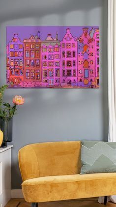 a living room with a yellow couch and pink painting on the wall above it's headboard