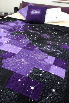 a purple and black bedspread with stars on it