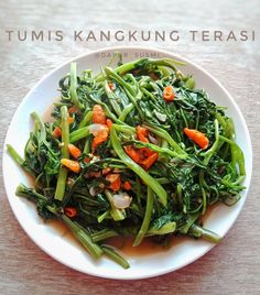 a white plate topped with greens and carrots