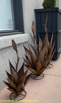 two metal planters sitting on the side of a building