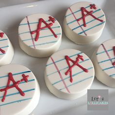 six decorated cookies with red and blue icing on top of a white tray in the shape of letters a to z