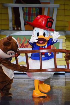 two cartoon characters dressed in costumes and one is holding a basket with fireman duck on it