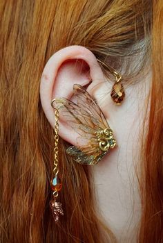 Please visit my own independent webstore for over 100 more colours and variations of my pieces and reduced prices. - https://ausgefuchstart.de/en/ Winged Earlobe Faerie Ear Cuffs. These extraordinary cuffs consists of golden wire with some golden teardrop pearls. two pair of small forest green fairy wings on each side and some golden chain with magical pearls and a rose golden leafs on it. As this design is very difficult to create I decided to offer these cuffs just as OOAK pieces on Shop Updat Green Fairy Wings, Small Forest, Magical Accessories, Green Fairy, Wrap Earrings, Golden Chain, Funky Jewelry, Fairy Wings, Ear Cuffs