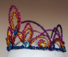 a tiara made out of beads on top of a white mannequin headdress