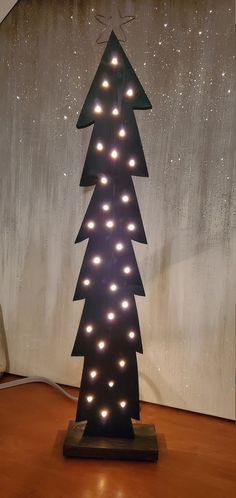 a lighted christmas tree sitting on top of a wooden table