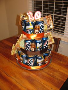 a tiered cake made out of cans on top of a wooden table