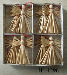 four wooden sticks in a box with red string tied around the top and one is shaped like an angel