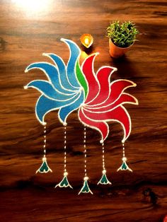 a wooden table topped with two colorful roosters next to a potted plant on top of it