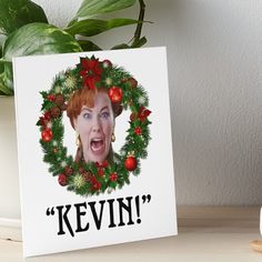 a christmas card with the image of revin on it and holly wreath around her face