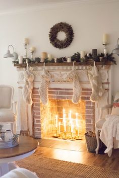 a living room filled with furniture and a fire place in front of a mantle covered in stockings