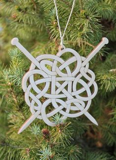 a wooden ornament hanging from a tree with two crossed swords in the center