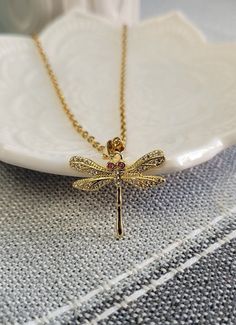 "This cute, detailed dragonfly necklace would make a great gift.  The dragonfly is 14 karat gold plated and has clear and fuchsia colored zirconia stones.  The chain is gold colored stainless steel and you can choose the length of the necklace. The dragonfly measures 7/8\" wide x 3/4\" tall  This would make a great gift for a birthday, an anniversary, Christmas or any other occasion. All jewelry items come in a gift box." Gold Dragonfly Necklace For Gift, Elegant Gold Dragonfly Necklace, Yellow Gold Dragonfly Jewelry Gift, Yellow Gold Dragonfly Jewelry For Gifts, Elegant Gold Dragonfly Jewelry, Anniversary Ornament, Wood Guest Book, 1st Wedding Anniversary, Memory Locket