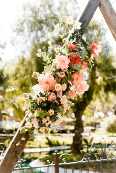 a floral arrangement hanging from a wooden structure