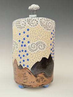 a ceramic pot with blue and white designs on the top, sitting on a gray surface