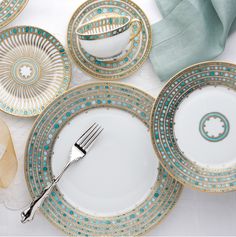 a table topped with plates and silverware on top of a white table cloth