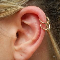 a close up of a person's ear with a gold ring on the side