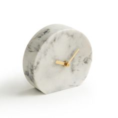 a marble clock with gold hands on a white background