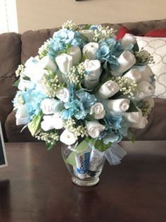 a laptop computer sitting on top of a table next to a vase filled with flowers