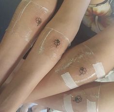 two women's legs with tattoos on them, both covered in clear plastic wrap