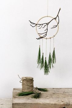 a wooden table topped with a piece of string and a tree branch hanging from it