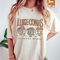 a woman wearing a t - shirt that says luke combs country music