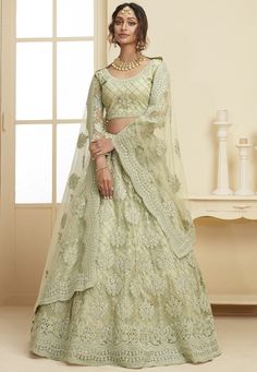 a woman in a light green lehenga with matching blouse and dupatta