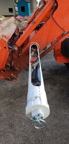 the back end of an orange truck with a man in it's seat sitting inside