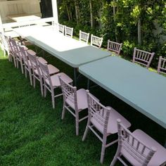 a long table and chairs sitting in the grass