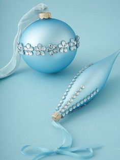 a blue ornament and ribbon on a light blue background