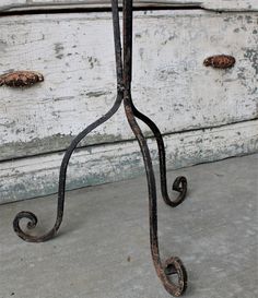 an old iron stand on concrete with rusted metal handles and two drawers in the background