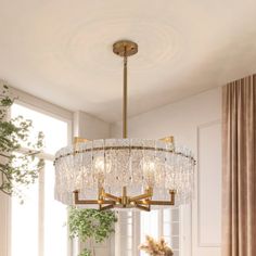 a chandelier hanging from the ceiling in a dining room with chairs and table