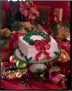 a decorated christmas cake sitting on top of a table next to other holiday decorations and presents