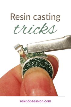 a hand holding a small metal object with the words resin casting tricks written on it