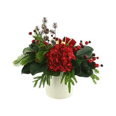 a white vase filled with red flowers and greenery