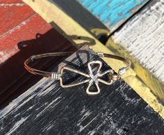 Handmade in the Mississippi Delta! This listing is for the 14k Gold Filled cross bracelet wrapped in Argentium Sterling silver wire. The cross measures 1 inch in length, and 3/4 inch in width. I formed this cross bracelet with a single piece of wire before hammering it. The Bracelet is then tumbled for hours fro extra shine! After this process I am then able to wrap the Bands and center of the cross with the Sterling silver wire. This has been a very popular bracelet! This is an original cross b Louisiana Jewelry, Music Bracelet, Popular Bracelets, Mississippi Delta, Hammered Gold, Christian Cross, Wire Wrapped Rings, Cross Bracelet, Gold Cross