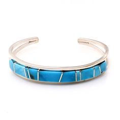 Experience the exquisite craftsmanship of Navaho artist Sam Arviso with this handcrafted Turquoise channel inlay bracelet. Measuring 5 1/4" from tip to tip with a 1" opening, this bracelet is expertly crafted and not easily adjustable. Its sleek 3/8" width and weight of approximately 17.4 grams make it a stunning addition to any jewelry collection. Adjustable Blue Inlay Cuff Bracelet, Adjustable Blue Cuff Bracelet With Inlay, Southwestern Style Turquoise Inlay Bracelets, Southwestern Turquoise Inlay Bracelet, Artisan Turquoise Bracelets With Inlay, Artisan Turquoise Bracelet With Inlay, Adjustable Turquoise Cuff Bracelet With Polished Finish, Adjustable Turquoise Polished Cuff Bracelet, Adjustable Turquoise Bracelet With Polished Finish