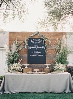 a table topped with cake next to a wooden sign