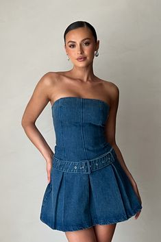 An icon.The LEE is a denim dress featuring a strapless neckline, pleated skirts, and a mini length. It is designed with a removable self-fabric belt that cinches the waist for an hourglass figure. Enclosed with a side zip for invisibility, this denim dress creates a polished and seamless appearance when worn. Fitted Mini Dress With Belt For Summer, Strapless Neckline, Faux Leather Boots, Pleated Skirts, Lee Denim, Concert Fits, Pleated Mini Dress, Fabric Belt, Bad Girl